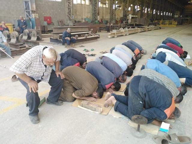 العمال يؤدون الصلاة خلال الاعتصام 